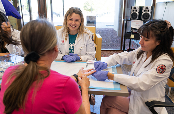 Two healthcare workers and a patient sitting at a table