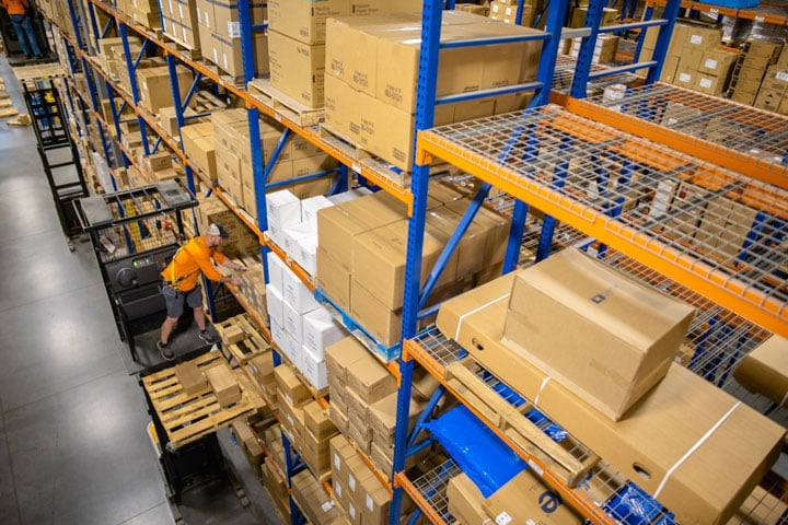 <span>Forklift order picker in a third-party logistics warehouse, surrounded by storage shelves neatly stacked with boxes.  </span>