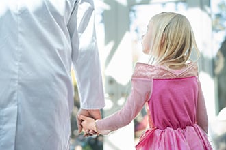 A little girl holding a doctor's hand