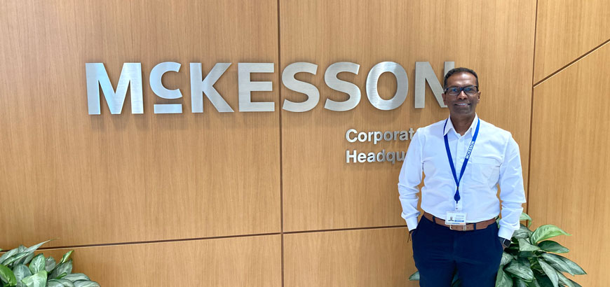 Ram standing in front of the McKesson logo inside a McKesson office