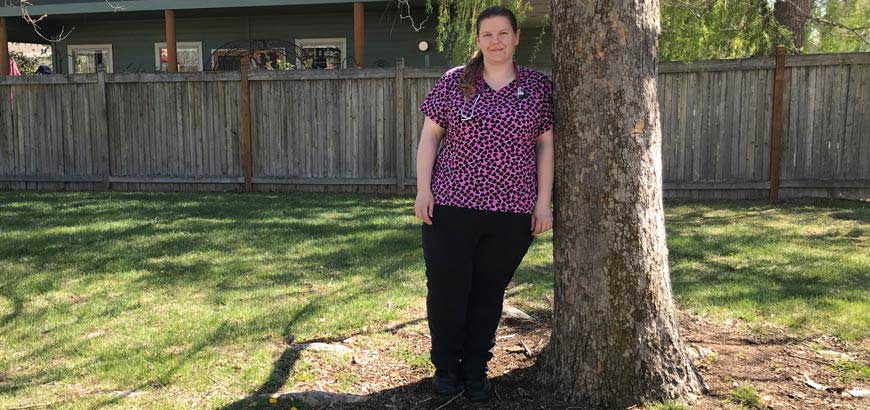 A nurse leaning against a tree