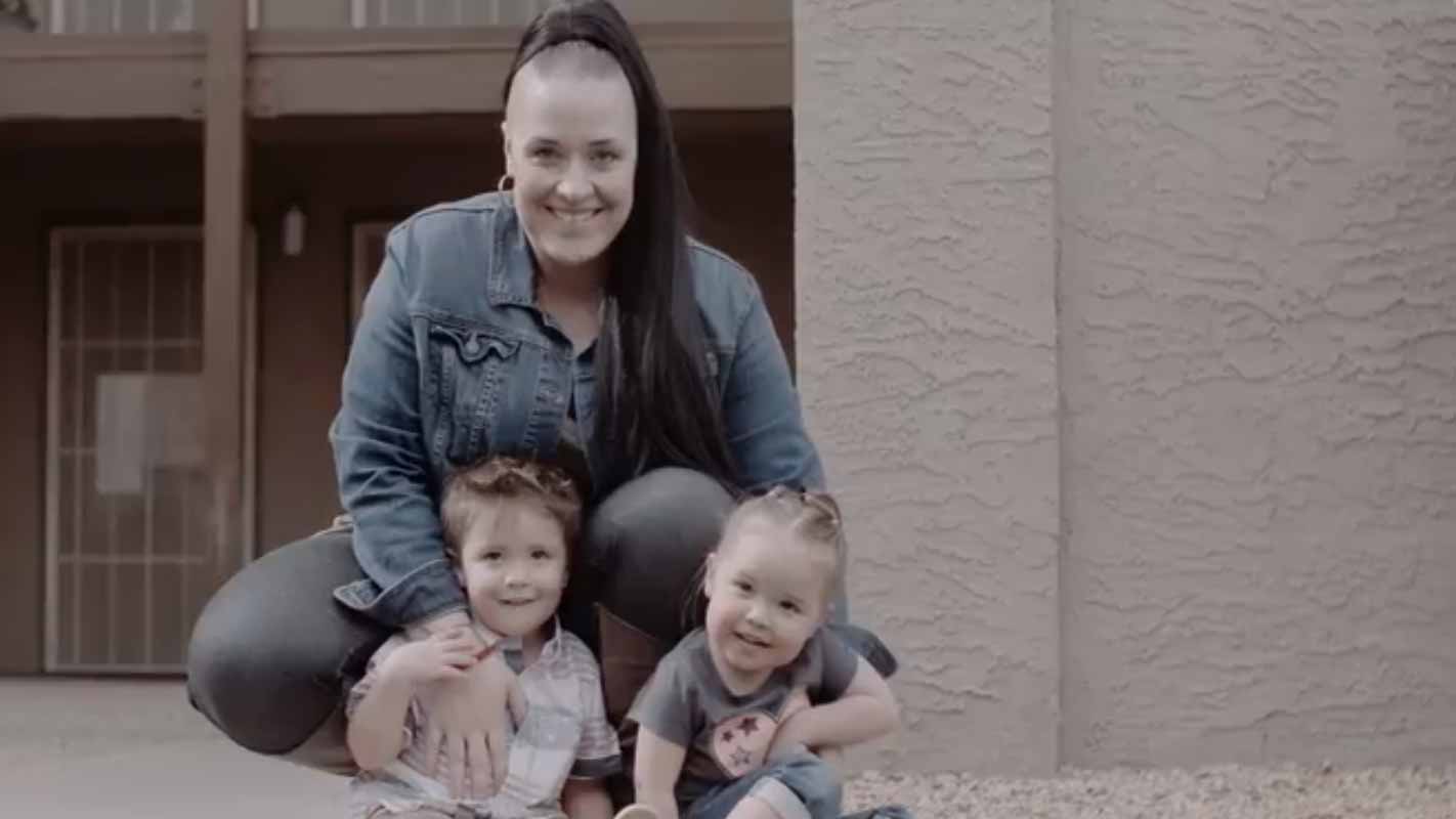 Shaunette Nelson sitting on the porch with her two children