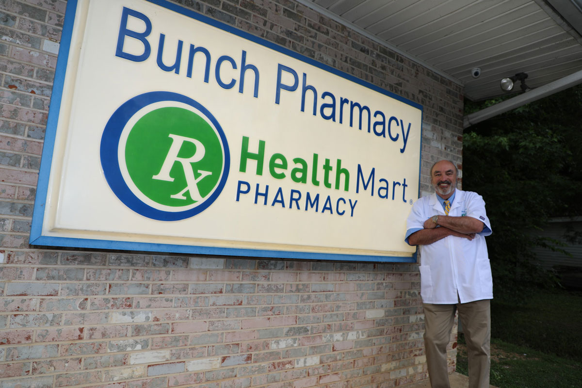 Buddy Bunch poses with the sign for his pharmacy<br>  