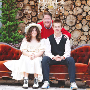 Katie Ewers and her two children sit on an ornate bench