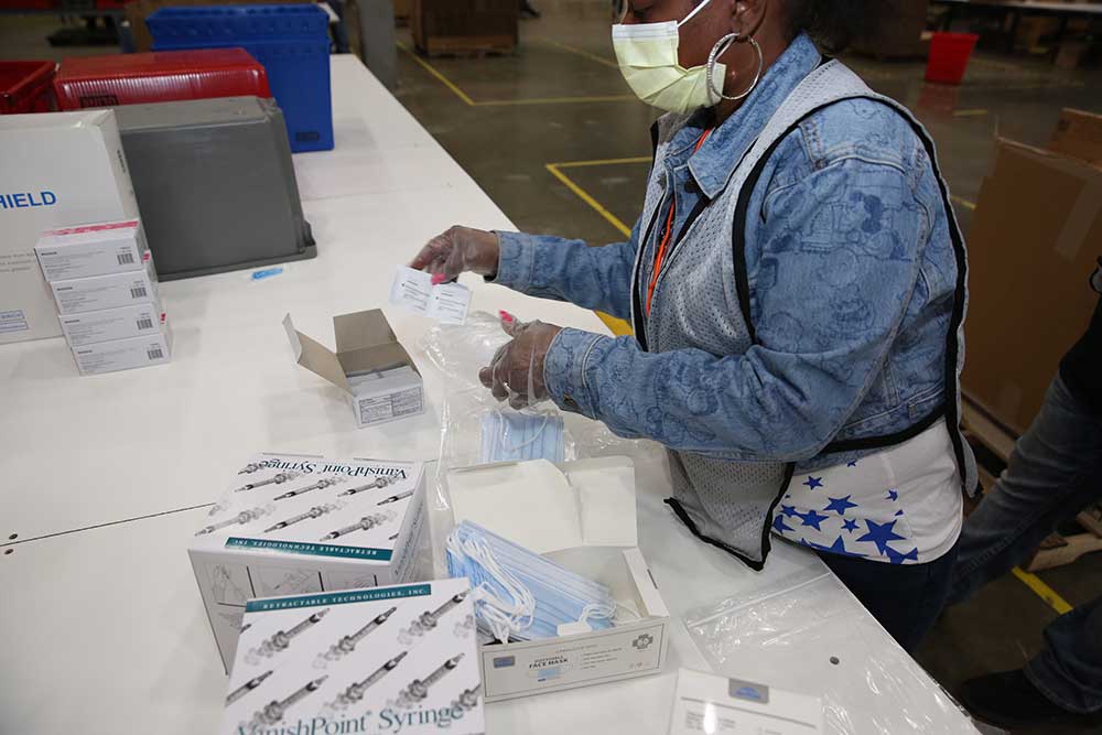 A worker assembling a vaccine kit