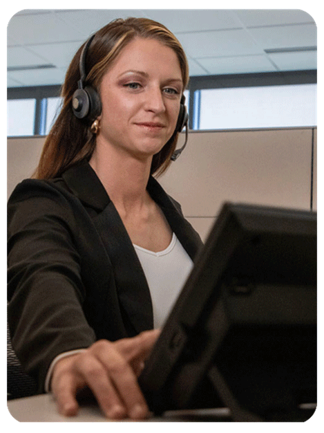 Woman at a computer wearing a telephone headset